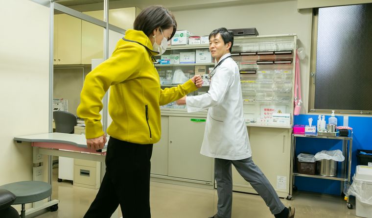 院長が患者さんの歩き方を見ながら運動を指導している様子